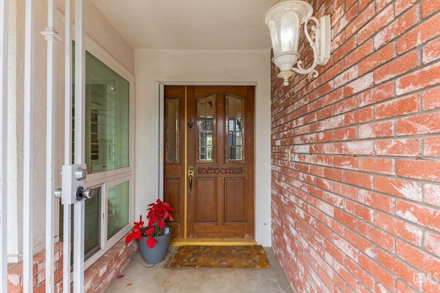 doorway to property featuring brick siding