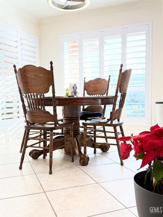 tiled dining room featuring crown molding