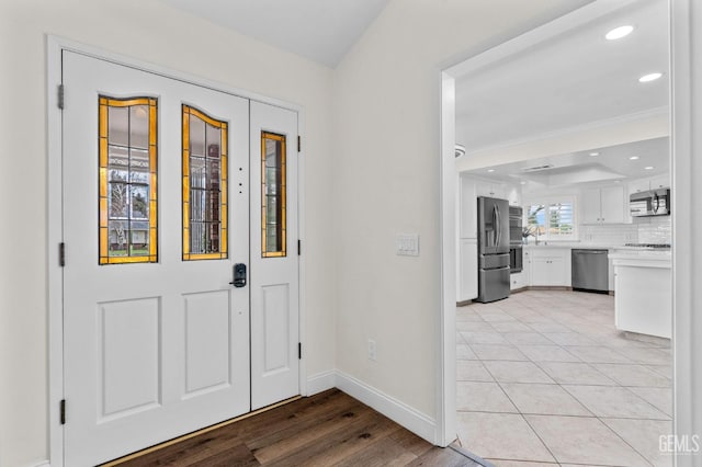 foyer entrance featuring light wood-style floors, recessed lighting, and baseboards