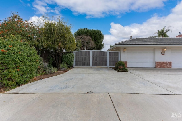 exterior space with driveway, a gate, and fence