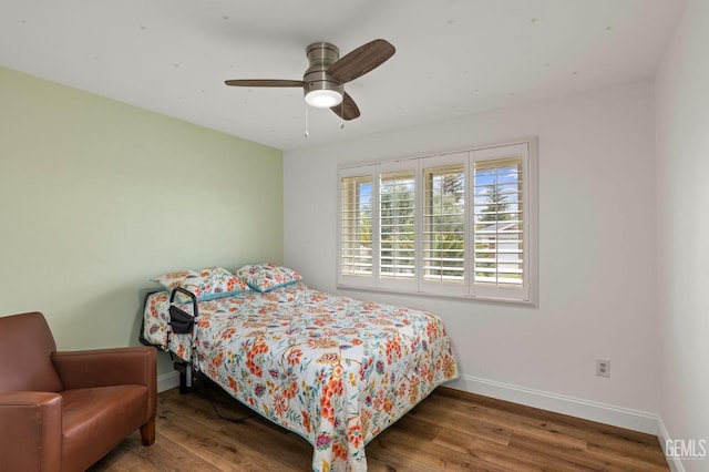 bedroom featuring a ceiling fan, baseboards, and wood finished floors