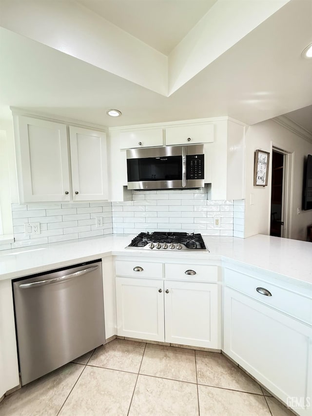 kitchen featuring white cabinets, appliances with stainless steel finishes, and backsplash