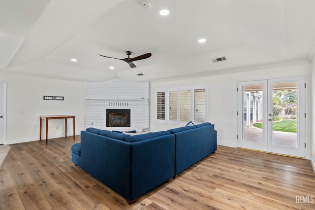 living room featuring recessed lighting, visible vents, baseboards, light wood-style floors, and a brick fireplace