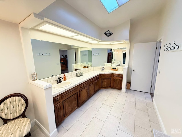 bathroom with tile patterned floors, a skylight, and vanity