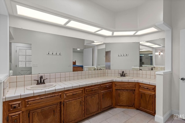 full bathroom featuring tile patterned floors, a sink, and double vanity