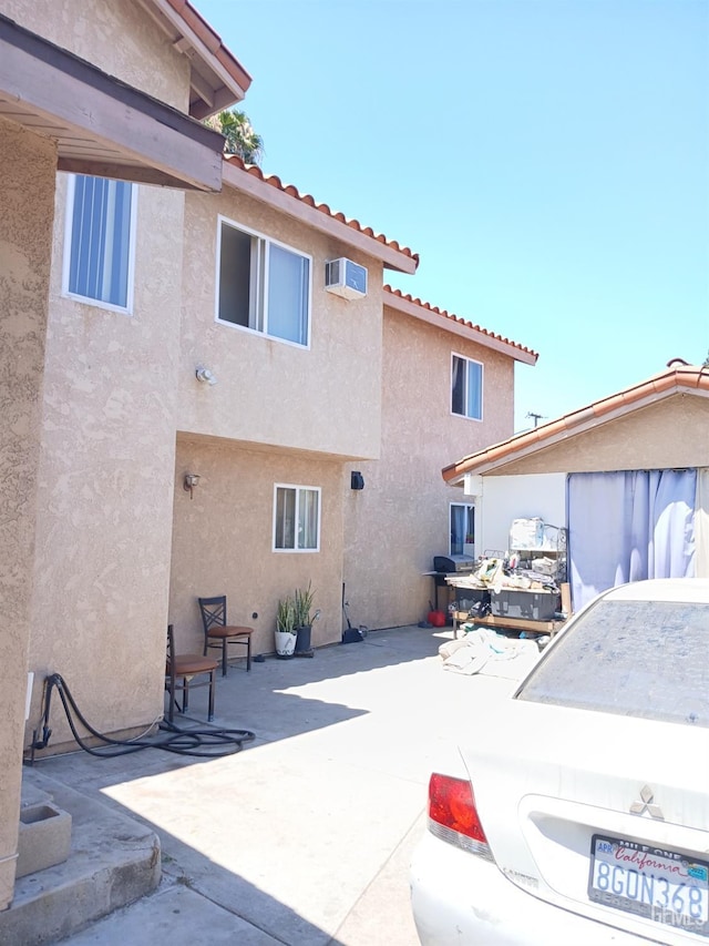 back of property featuring an AC wall unit