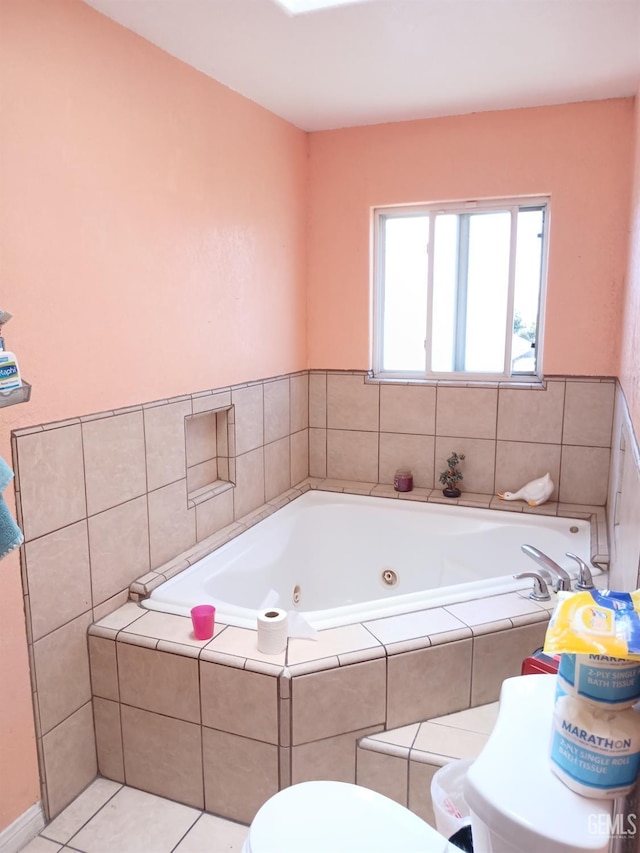 bathroom with tiled tub, tile patterned flooring, and toilet