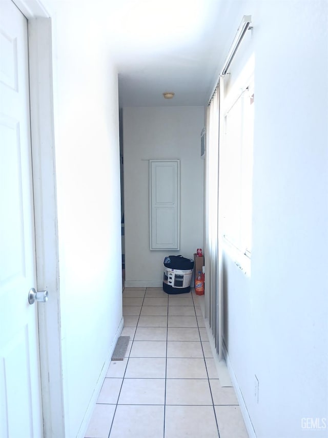 hallway featuring a wealth of natural light and light tile patterned flooring