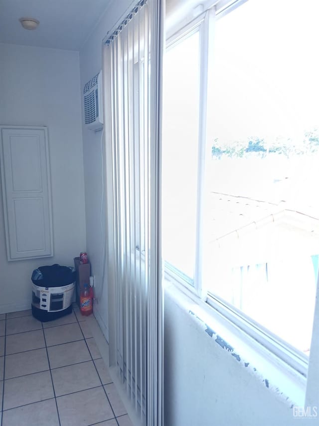 hallway with a wall mounted air conditioner and light tile patterned floors