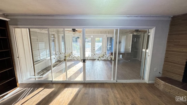 doorway to outside featuring crown molding, ceiling fan, wood-type flooring, and french doors