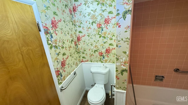 bathroom featuring toilet and tiled shower / bath combo