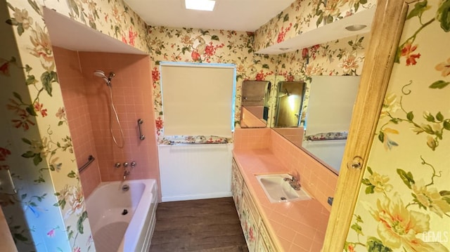 bathroom featuring vanity, tiled shower / bath combo, and hardwood / wood-style floors