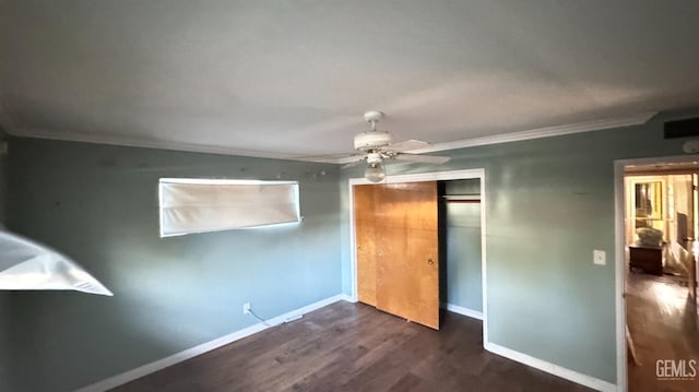 unfurnished bedroom with dark hardwood / wood-style flooring, crown molding, ceiling fan, and a closet