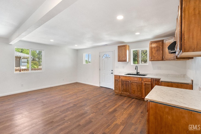 438 Cedar Ave, Earlimart, CA 93219 - kitchen with brown cabinetry, a sink, dark wood-style flooring, baseboards, and plenty of natural light