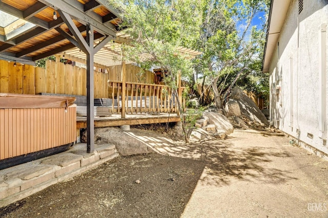 view of yard featuring a wooden deck and a hot tub