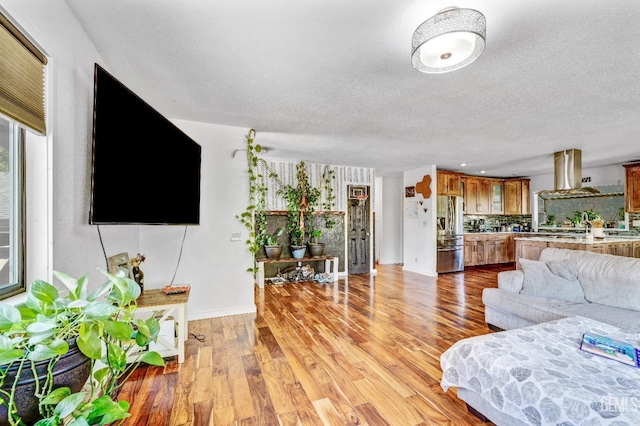 living room with a textured ceiling and light wood-type flooring