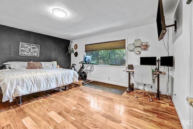 bedroom with wood-type flooring and a textured ceiling