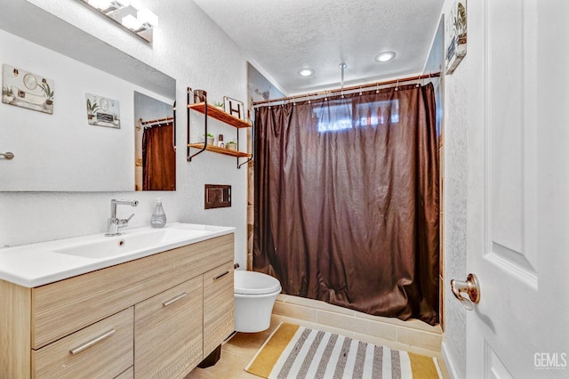 bathroom with vanity, tile patterned floors, a shower with shower curtain, toilet, and a textured ceiling