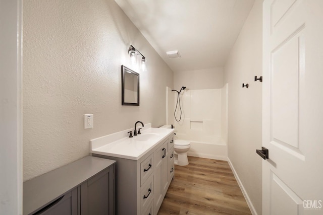 bathroom featuring bathing tub / shower combination, vanity, toilet, wood finished floors, and baseboards