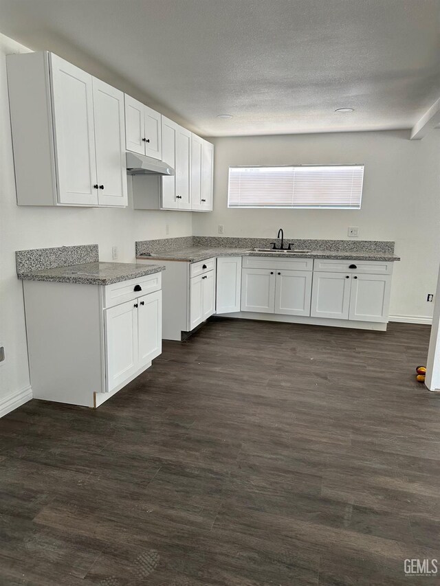 1012 Yosemite Dr, Bakersfield, CA 93308 - kitchen with under cabinet range hood, white cabinets, dark wood-type flooring, and a textured ceiling