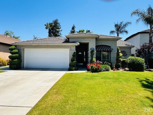 518 Lewisham St, Bakersfield, CA 93311 - view of front of home with an attached garage, driveway, a front lawn, a tile roof, and stucco siding