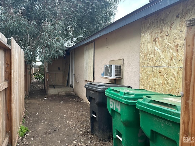 view of side of home with fence and stucco siding