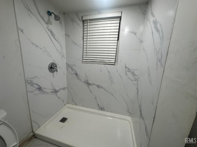 bathroom with marble finish floor, a marble finish shower, and toilet