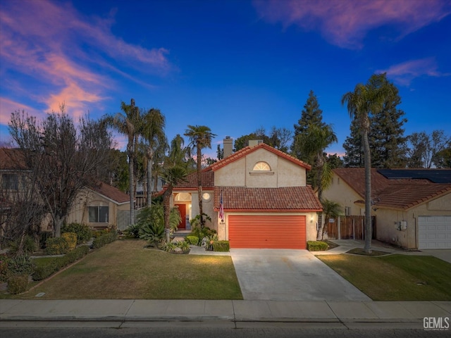 mediterranean / spanish-style home featuring a garage and a lawn