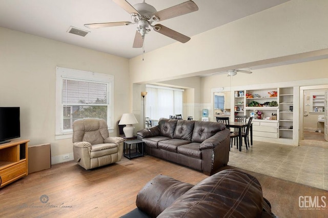 living area featuring ceiling fan, wood finished floors, and visible vents