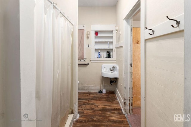 bathroom featuring a sink, a shower with shower curtain, and wood finished floors