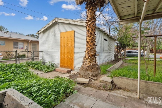 view of outdoor structure featuring a gate, fence, and an outdoor structure