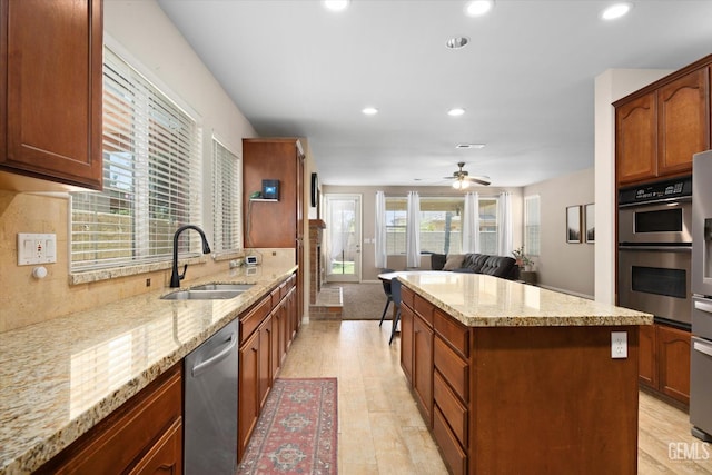 9221 Via Lugano, Bakersfield, CA 93312 - kitchen featuring a sink, stainless steel appliances, a center island, recessed lighting, and light stone counters