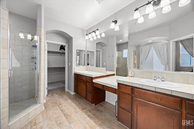 9221 Via Lugano, Bakersfield, CA 93312 - full bathroom with a shower stall, two vanities, a spacious closet, and wood finished floors