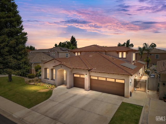 9221 Via Lugano, Bakersfield, CA 93312 - mediterranean / spanish-style house with a gate, a garage, driveway, a tiled roof, and stucco siding