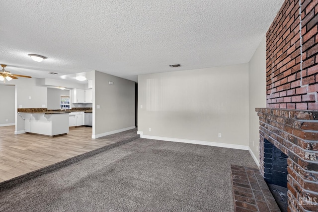 1929 Belmont St, Delano, CA 93215 - unfurnished living room with a textured ceiling, a fireplace, baseboards, and a ceiling fan
