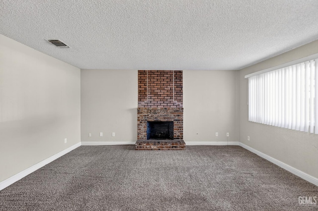 1929 Belmont St, Delano, CA 93215 - unfurnished living room featuring a textured ceiling, dark carpet, a brick fireplace, and baseboards