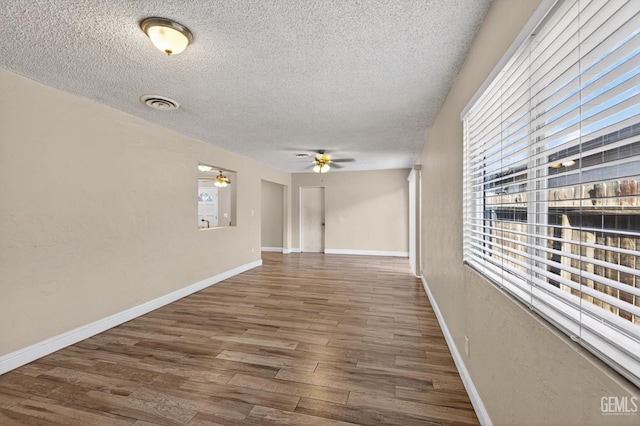 1929 Belmont St, Delano, CA 93215 - empty room featuring a textured ceiling, wood finished floors, ceiling fan, and baseboards