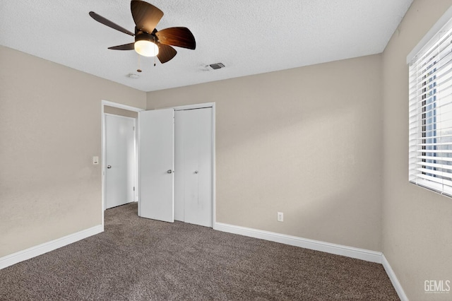 1929 Belmont St, Delano, CA 93215 - unfurnished bedroom with carpet, multiple windows, baseboards, a textured ceiling, and a closet