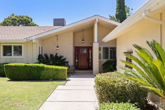 601 Vista Verde Way, Bakersfield, CA 93309 - entrance to property featuring brick siding, board and batten siding, a yard, roof with shingles, and a chimney