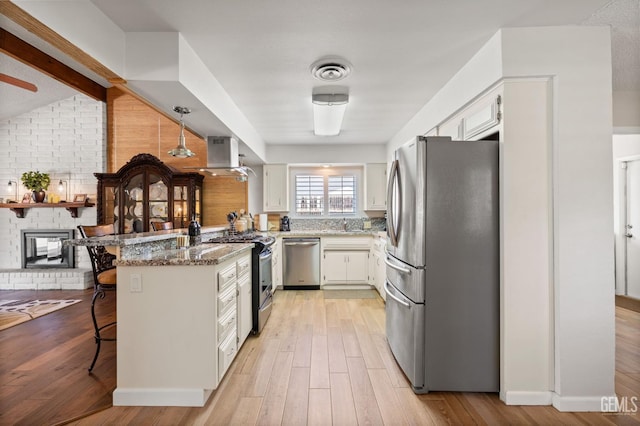 601 Vista Verde Way, Bakersfield, CA 93309 - kitchen featuring appliances with stainless steel finishes, a peninsula, a breakfast bar, light stone counters, and wall chimney exhaust hood