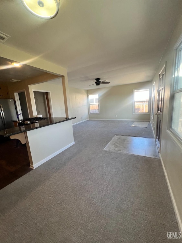 unfurnished living room featuring carpet flooring and ceiling fan