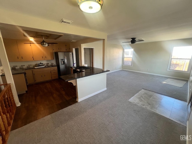 kitchen with plenty of natural light, ceiling fan, stainless steel fridge with ice dispenser, and a breakfast bar area