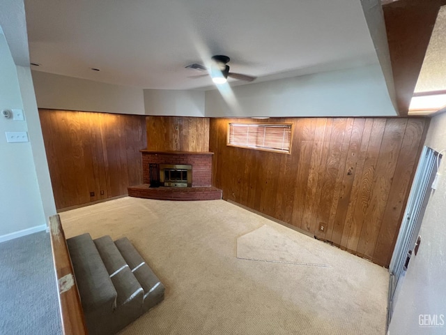 unfurnished living room featuring wood walls, light carpet, and a brick fireplace