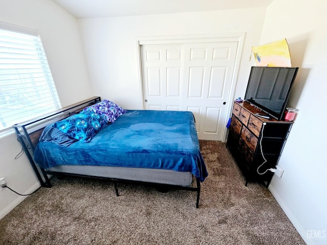 bedroom with a closet and dark carpet