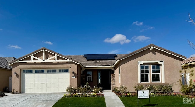 ranch-style home featuring a garage, concrete driveway, solar panels, and stucco siding