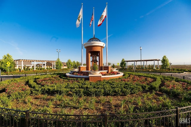 view of property's community with fence and a pergola