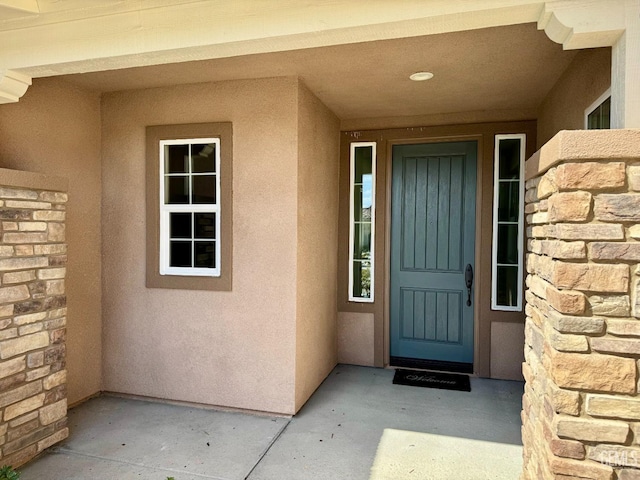 doorway to property featuring stucco siding