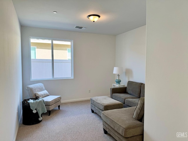 living area featuring carpet floors, visible vents, and baseboards