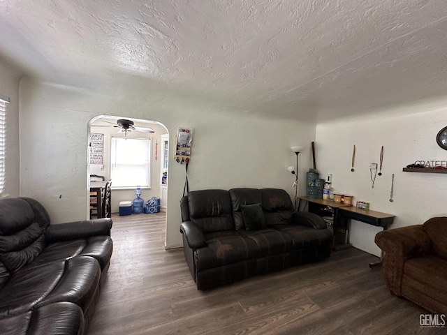 living room with hardwood / wood-style floors, ceiling fan, and a textured ceiling