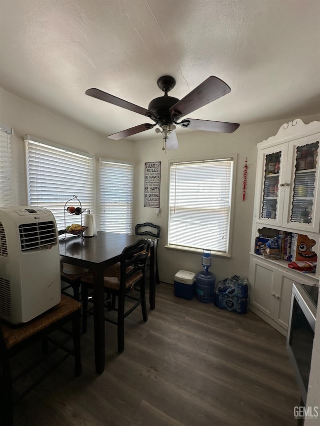 dining area featuring a textured ceiling, ceiling fan, dark wood-type flooring, and a wealth of natural light